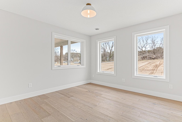 spare room featuring light wood-style flooring and baseboards