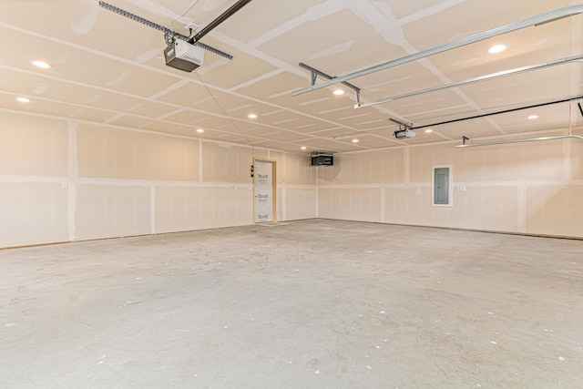 garage with electric panel, recessed lighting, and a garage door opener