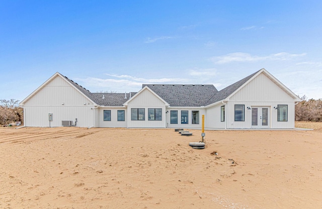 back of house featuring central AC unit, french doors, and a shingled roof