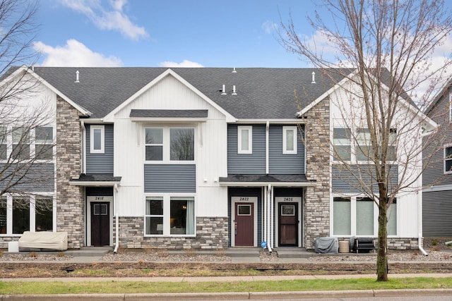 multi unit property with a shingled roof and stone siding