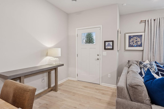 foyer with baseboards and light wood finished floors