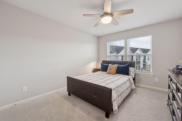 bedroom featuring baseboards, a ceiling fan, and light colored carpet