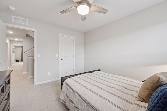 bedroom with visible vents, a ceiling fan, baseboards, and light carpet