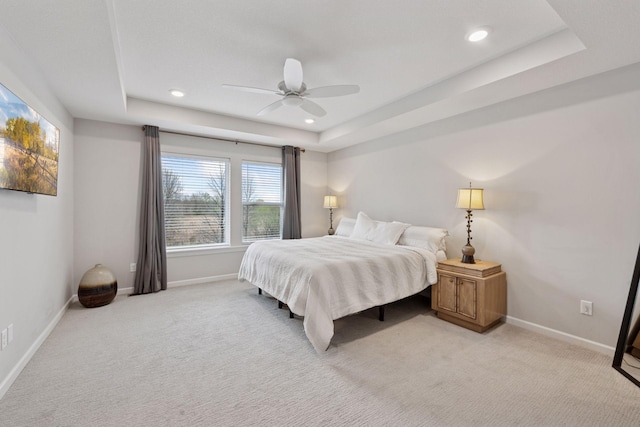 bedroom with recessed lighting, baseboards, light carpet, and a raised ceiling
