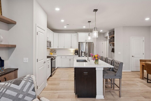 2422 Blossom Cir, Orono, MN 55356 - kitchen with stainless steel appliances, a sink, recessed lighting, a breakfast bar area, and light countertops