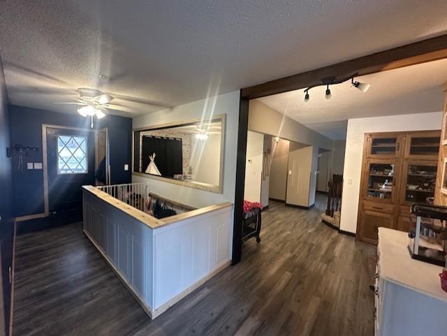 kitchen with a ceiling fan, a textured ceiling, light countertops, and dark wood-style floors