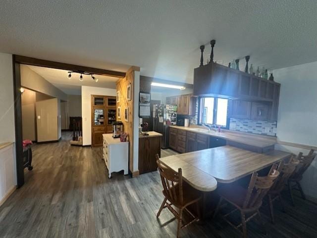 dining room featuring track lighting, wood finished floors, and a textured ceiling