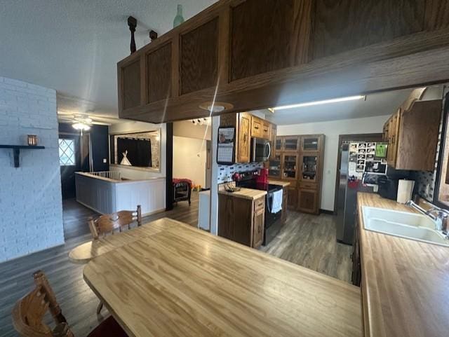 kitchen with light countertops, appliances with stainless steel finishes, wood finished floors, and a sink