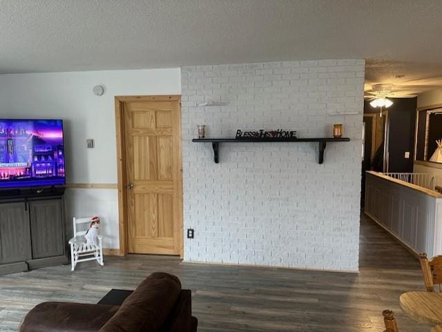 living area with a textured ceiling, wood finished floors, and a ceiling fan