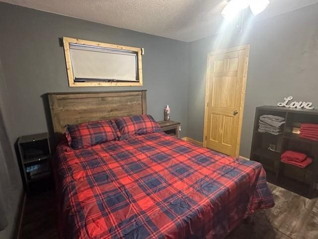 bedroom with a textured ceiling and wood finished floors