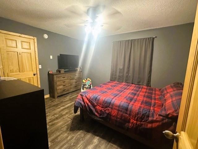 bedroom featuring a textured ceiling, a ceiling fan, and wood finished floors