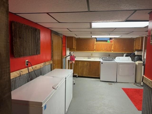 clothes washing area with cabinet space, washer and clothes dryer, and a sink