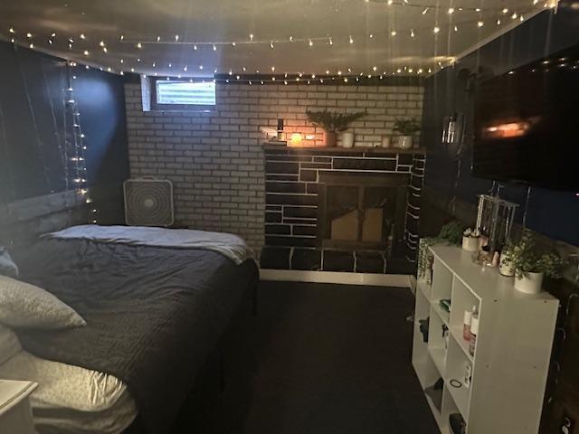 bedroom with brick wall and a fireplace