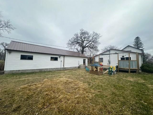 back of house with a yard and metal roof