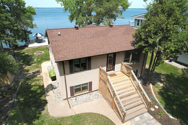 45257 Jack Pine Dr, Perham Twp, MN 56573 - view of front of home featuring a shingled roof, a water view, a front yard, a fire pit, and stairs