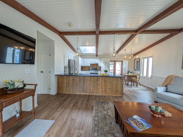45257 Jack Pine Dr, Perham Twp, MN 56573 - living room with light wood finished floors, beam ceiling, and a chandelier