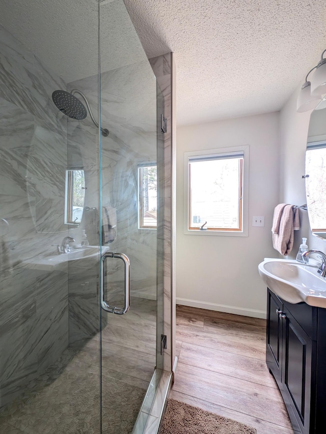 45257 Jack Pine Dr, Perham Twp, MN 56573 - bathroom with a textured ceiling, vanity, a stall shower, baseboards, and wood finished floors