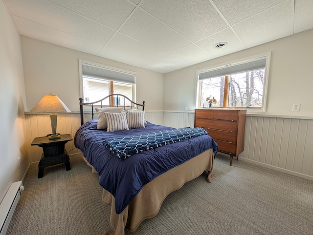45257 Jack Pine Dr, Perham Twp, MN 56573 - carpeted bedroom featuring baseboard heating, a wainscoted wall, and a drop ceiling