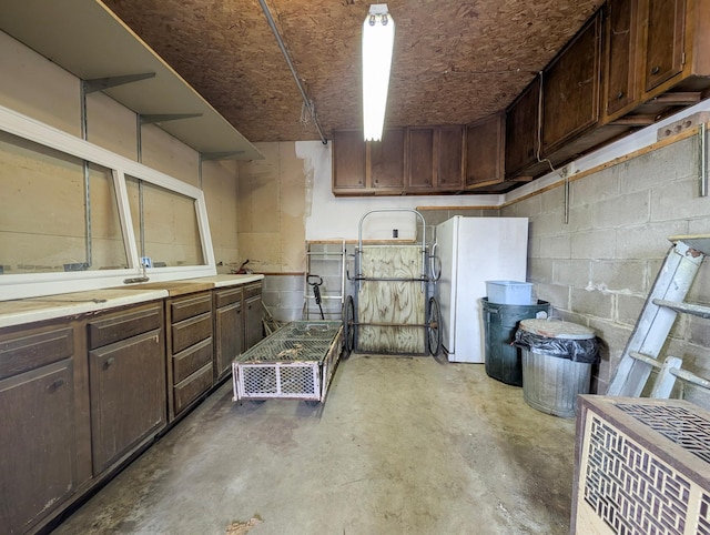 45257 Jack Pine Dr, Perham Twp, MN 56573 - below grade area featuring freestanding refrigerator and concrete block wall