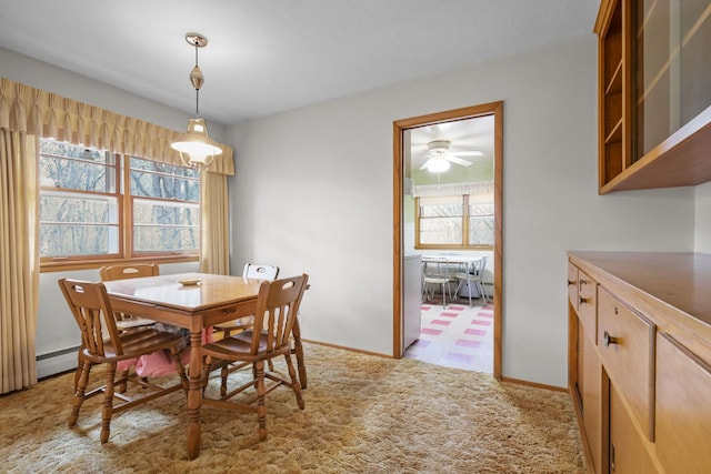 dining space featuring a ceiling fan, baseboards, and a baseboard radiator