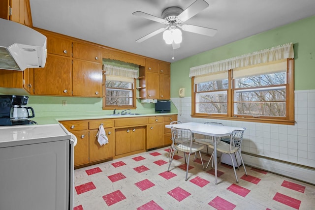 kitchen featuring tile walls, plenty of natural light, light countertops, and extractor fan