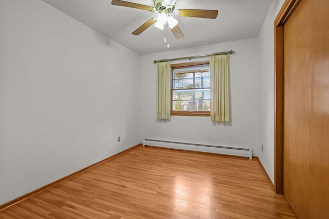 unfurnished bedroom featuring baseboards, light wood-style floors, baseboard heating, a ceiling fan, and a closet