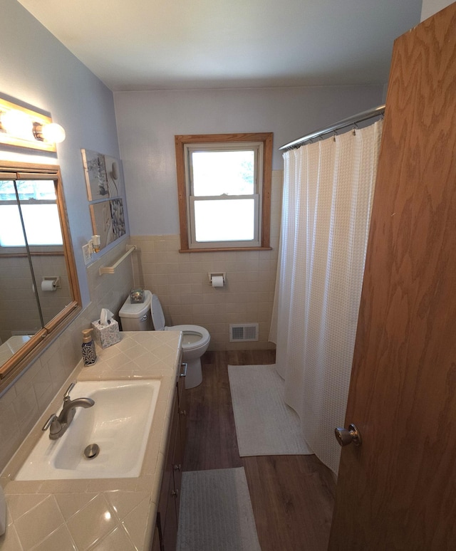 719 49th Ave NE, Columbia Heights, MN 55421 - bathroom with tile walls, vanity, wood finished floors, toilet, and wainscoting