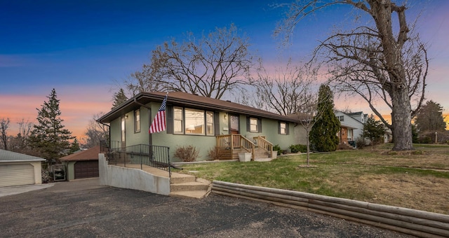 719 49th Ave NE, Columbia Heights, MN 55421 - view of front facade with an outdoor structure, a detached garage, stucco siding, and a lawn