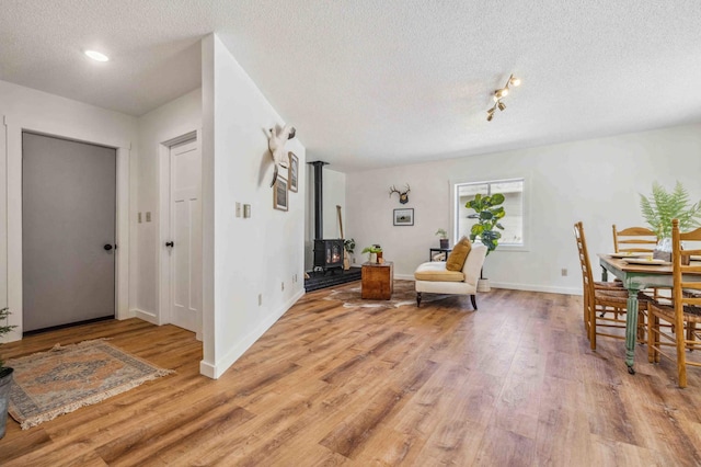 14347 Memorywood Dr, Baxter, MN 56425 - interior space featuring recessed lighting, light wood-style flooring, baseboards, a wood stove, and a textured ceiling