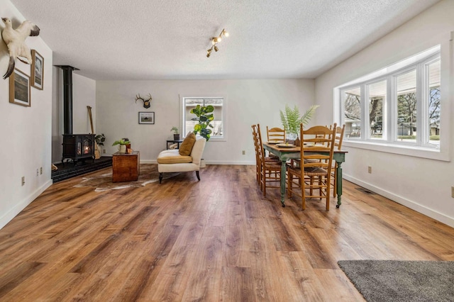 14347 Memorywood Dr, Baxter, MN 56425 - dining room featuring a textured ceiling, wood finished floors, visible vents, and a wood stove