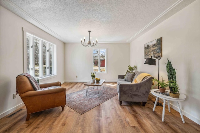 14347 Memorywood Dr, Baxter, MN 56425 - living area with a notable chandelier, visible vents, baseboards, a textured ceiling, and wood finished floors