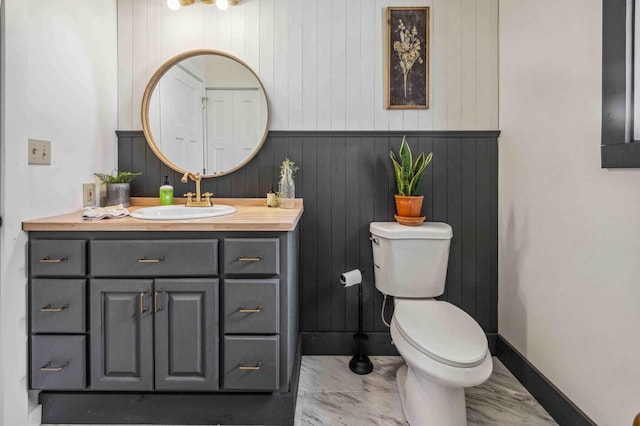 14347 Memorywood Dr, Baxter, MN 56425 - bathroom featuring marble finish floor, toilet, vanity, baseboards, and wooden walls