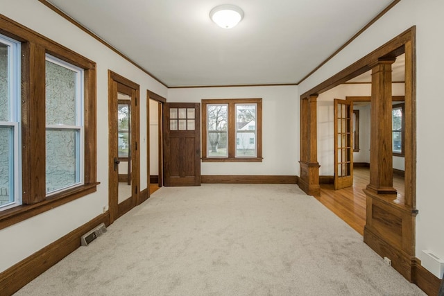 interior space featuring ornamental molding, a wealth of natural light, carpet flooring, and baseboards