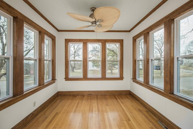 unfurnished sunroom featuring baseboards and a healthy amount of sunlight