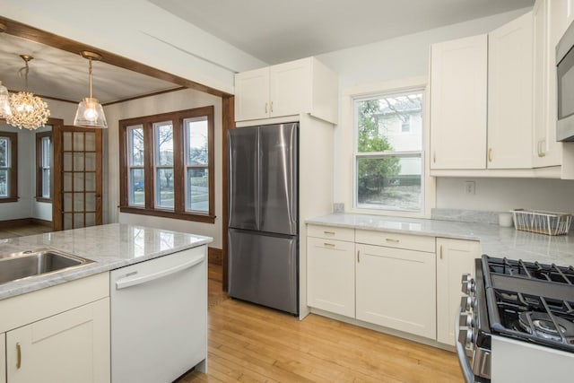 kitchen with a notable chandelier, light wood-style flooring, hanging light fixtures, white cabinetry, and appliances with stainless steel finishes