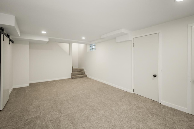below grade area featuring carpet flooring, stairway, baseboards, and recessed lighting
