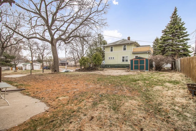 view of yard with an outdoor structure, a fenced backyard, and a storage unit