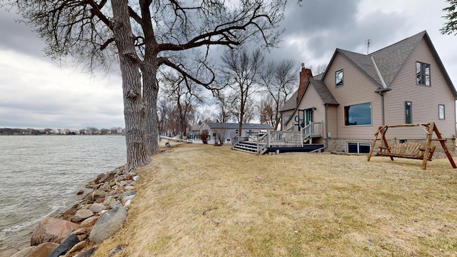 7030 147th Ave SE, Lake Lillian, MN 56253 - view of side of property with a chimney, a deck with water view, a yard, and roof with shingles