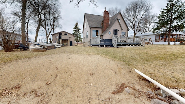 7030 147th Ave SE, Lake Lillian, MN 56253 - back of property featuring a chimney, a deck, a yard, and an outdoor structure
