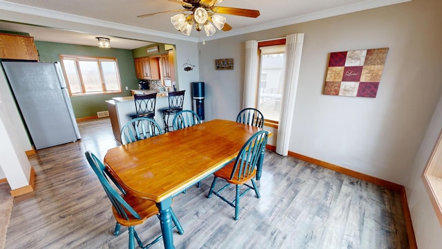 7030 147th Ave SE, Lake Lillian, MN 56253 - dining space with baseboards, ceiling fan, light wood-type flooring, and ornamental molding