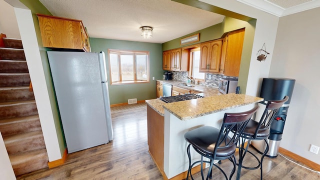 7030 147th Ave SE, Lake Lillian, MN 56253 - kitchen with freestanding refrigerator, a sink, wood finished floors, stainless steel dishwasher, and baseboards