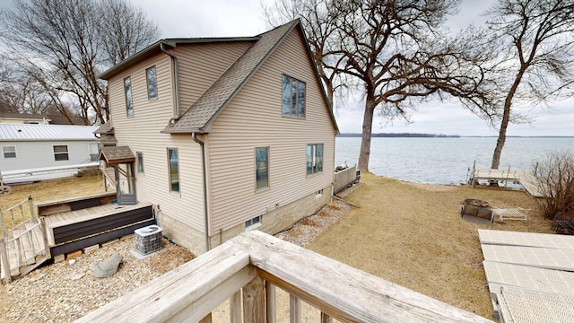 7030 147th Ave SE, Lake Lillian, MN 56253 - view of side of home with a water view, roof with shingles, and central AC unit