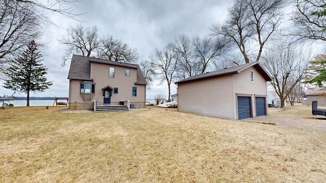 7030 147th Ave SE, Lake Lillian, MN 56253 - back of house with a lawn, a water view, roof with shingles, and an outdoor structure