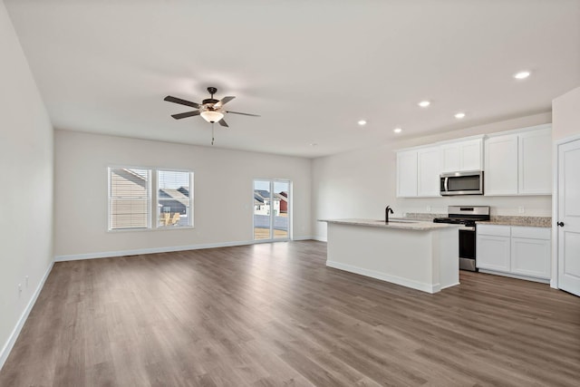 18761 Grant St NW, Elk River, MN 55330 - kitchen with appliances with stainless steel finishes, wood finished floors, recessed lighting, open floor plan, and white cabinets