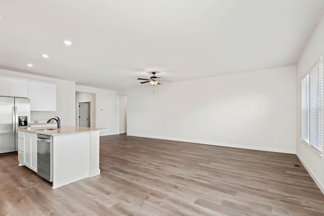 18761 Grant St NW, Elk River, MN 55330 - kitchen featuring appliances with stainless steel finishes, ceiling fan, an island with sink, light wood-type flooring, and recessed lighting