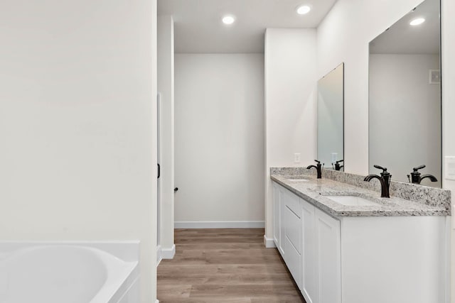 18761 Grant St NW, Elk River, MN 55330 - bathroom with double vanity, a garden tub, wood finished floors, and recessed lighting