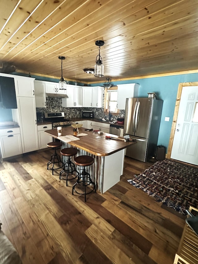 kitchen with white cabinets, tasteful backsplash, butcher block counters, dark wood-type flooring, and appliances with stainless steel finishes
