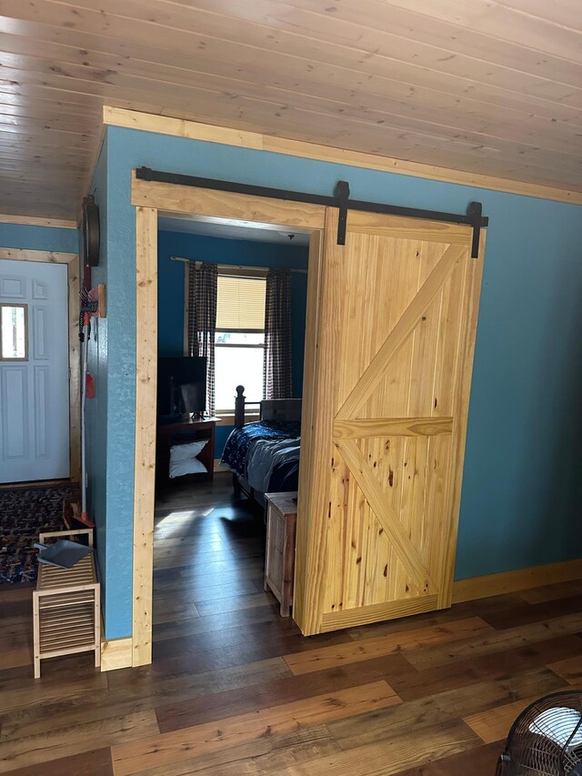 hallway with wood ceiling, hardwood / wood-style flooring, and a barn door