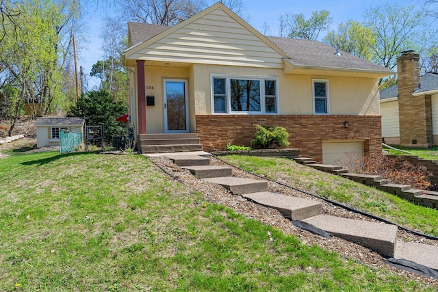 568 Frontenac Pl, Saint Paul, MN 55104 - bungalow-style home featuring stucco siding, entry steps, brick siding, a front lawn, and a shingled roof