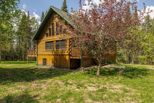 21339 Finch Dr, Park Rapids, MN 56470 - view of side of home with log exterior, a wooden deck, and a lawn